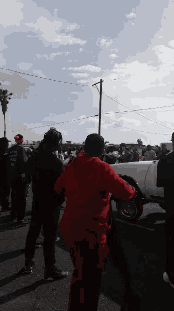 a person in a red hoodie with the word supreme on the back
