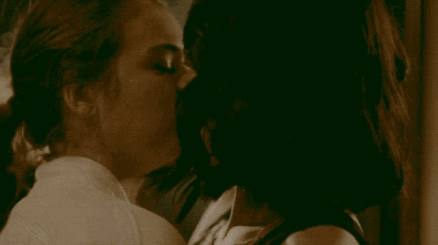 two women are kissing in a dark room with smoke coming out of their mouths
