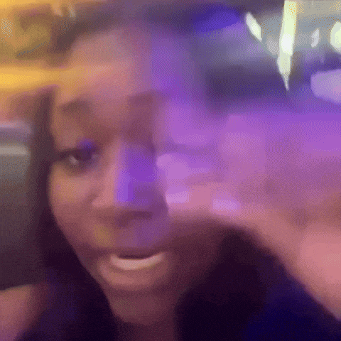 a woman is making a funny face in front of a purple light .