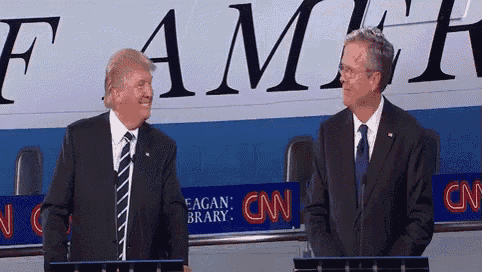 two men stand in front of a cnn sign