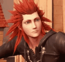 a man with red hair and blue eyes is wearing a black jacket and a necklace .