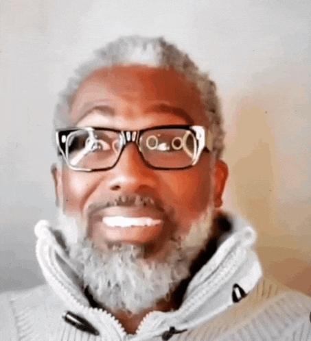 a man with glasses and a beard smiles for the camera