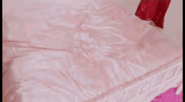 a woman is laying on a bed wearing a red dress .