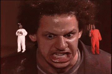 a man with a fork in his hand is making a funny face in front of a man in a white suit .