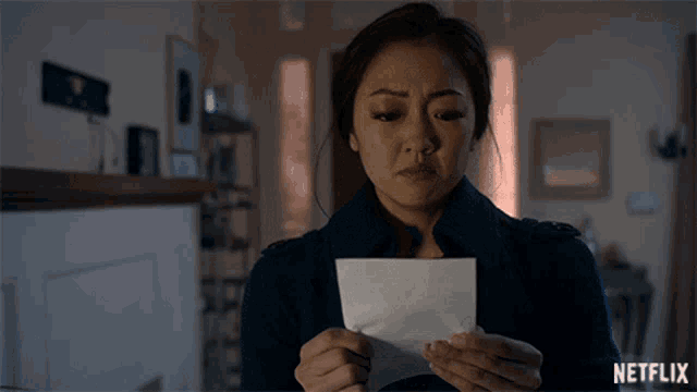 a woman holding a piece of paper with netflix on the bottom