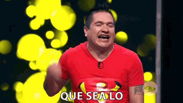a man wearing a red shirt with the word que sea lo on it