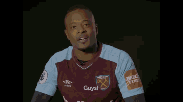 a man wearing a purple and blue soccer jersey is smiling and saying i love this game .