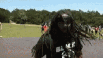 a man with dreadlocks is wearing a black shirt that says blk on it
