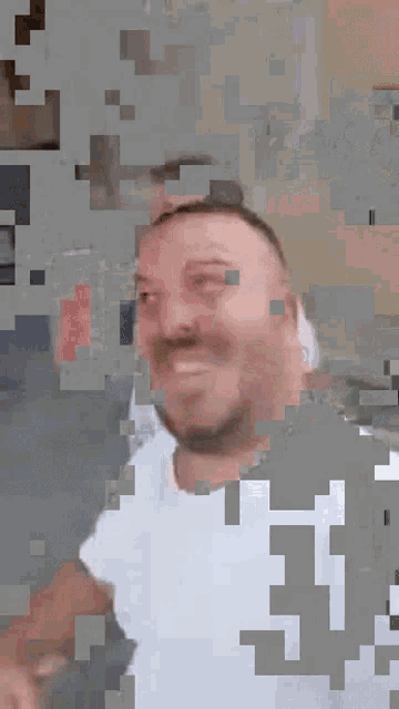 a man with a beard wearing a white shirt with the letter i on it