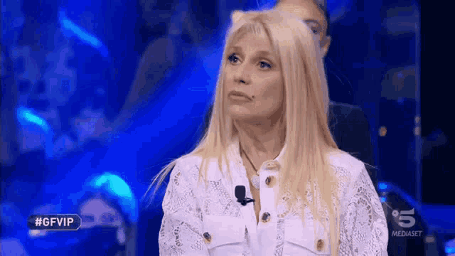 a woman in a white lace shirt is on a television show called gfvip
