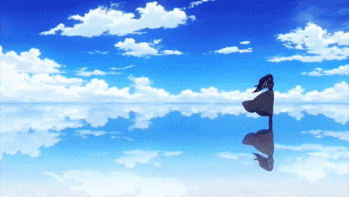 a person standing in the middle of a body of water with a blue sky in the background