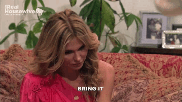 a woman is sitting on a couch with the words bring it written on the bottom