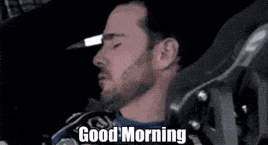 a man with a beard is sleeping with his eyes closed and the words `` good morning '' written above him .