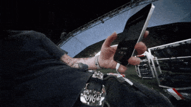a person is holding a cell phone with the time of 10:10 on the screen
