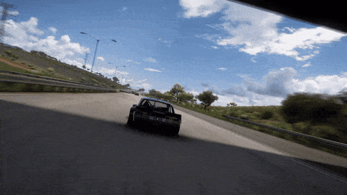 a car is driving down a highway with a license plate that says tmc on it