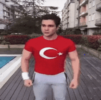 a man wearing a red t-shirt with a crescent moon and star on it