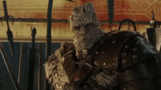 a statue of a man in armor standing in front of a bunch of swords .