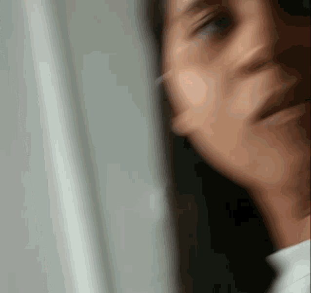 a blurry picture of a woman 's face is looking out a window .