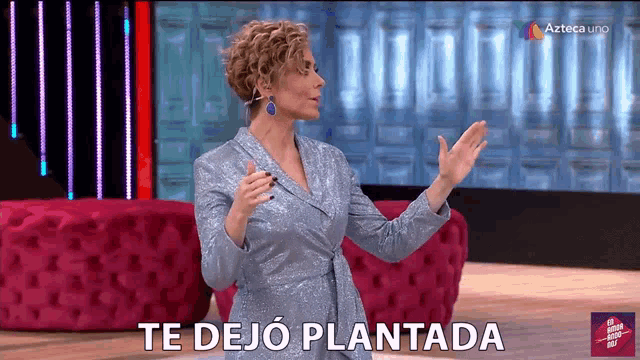 a woman stands in front of a screen that says te dejo plantada on it