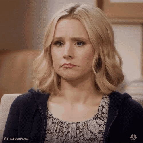 a woman is making a sad face while sitting on a couch .