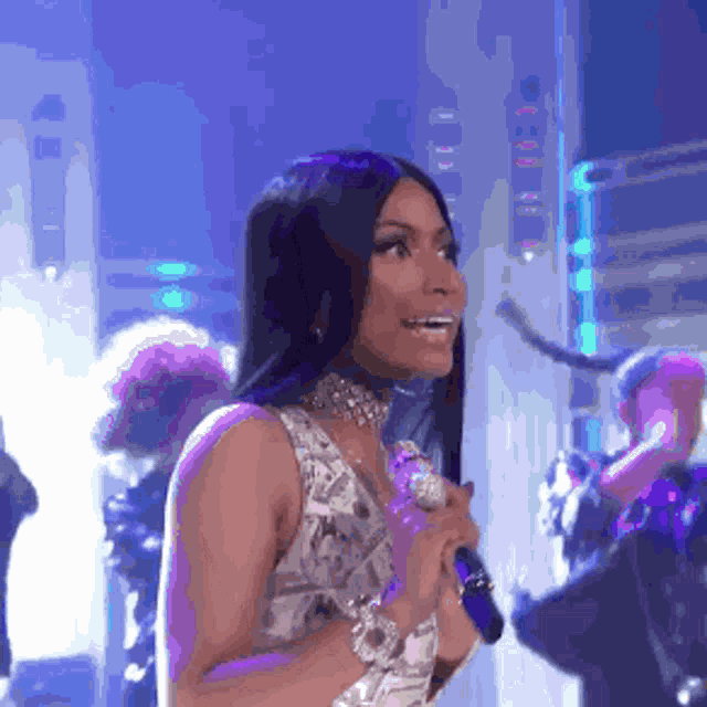 a woman is singing into a microphone with a choker around her neck