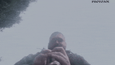 a man is taking a picture of himself with a photojoe logo in the background