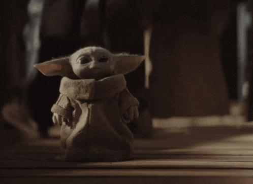 a small stuffed animal is sitting on a wooden floor in a dark room