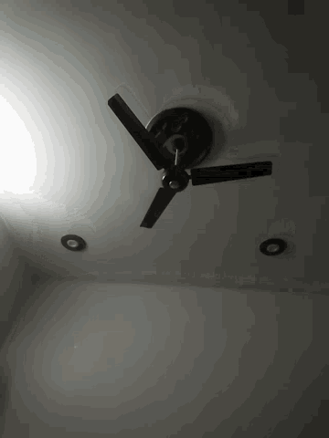 a black clock on a white wall shows the time as almost 5:00