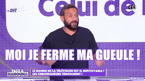 a man with a beard stands in front of a purple background that says moi je ferme ma gueule