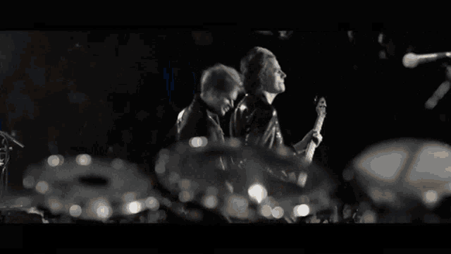 a man with a beard is clapping his hands in the dark