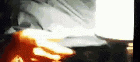 a blurry picture of a person standing in front of a stove with a flame coming out of it .