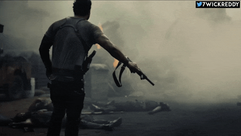 a man is holding a gun in front of a smokey scene with the twitter username 7wickreddy