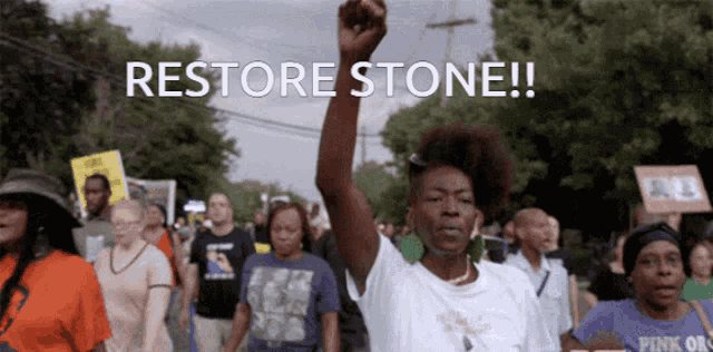 a group of protesters march down a street with the words restore stone written on the bottom