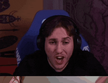 a man wearing headphones is making a funny face while sitting in a gaming chair .