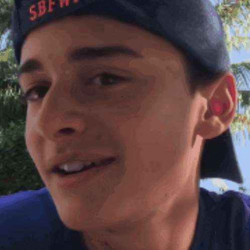 a close up of a young man wearing a sbf hat