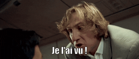 a man in a suit says je l'ai vu in front of another man