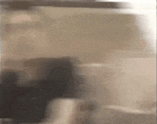 a blurry picture of a person standing in front of a glass door .