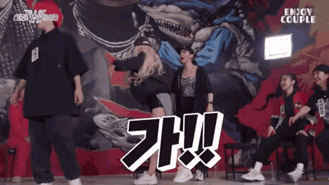 a group of people dancing in front of a wall that says enjoy couple on it