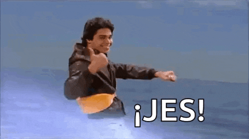 a man in a leather jacket is flying through the air with a yellow belt around his waist and giving a thumbs up .