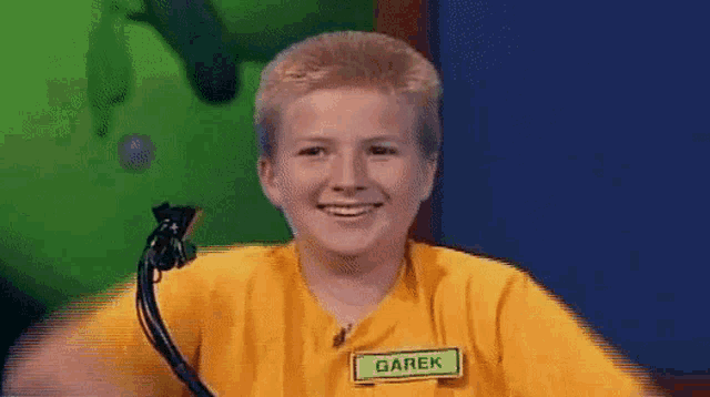 a young boy wearing a yellow shirt and a name tag that says garek