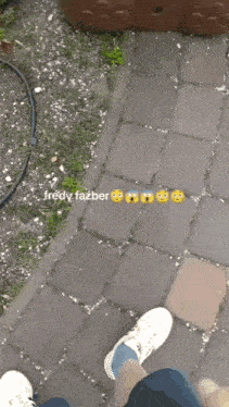 a person standing on a brick sidewalk with smiley faces and the name fredy fazber