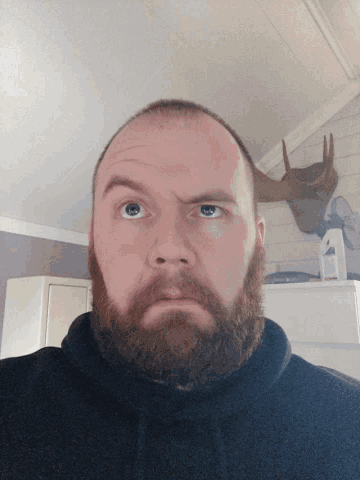 a man with a beard and moose antlers on the wall