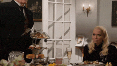 a woman sits at a table with a tray of food on it