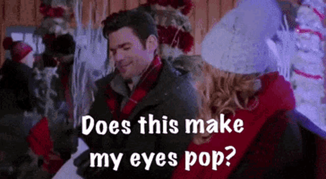 a man and woman are standing next to each other in front of christmas trees .
