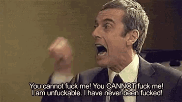 a man in a suit and tie is screaming with his mouth open and his fist in the air .