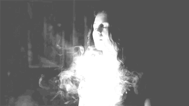 a black and white photo of a smoke coming out of a bottle .