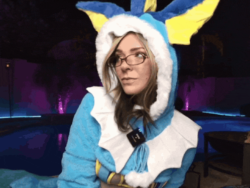 a woman wearing glasses and a blue and yellow costume with a hood