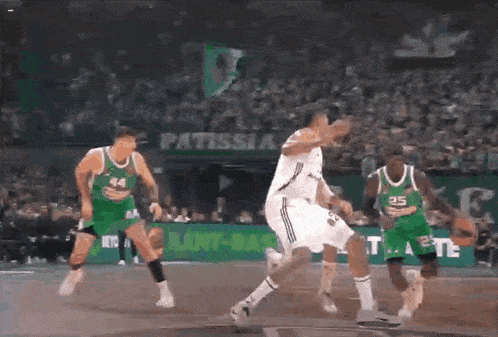 a group of basketball players are playing a game in front of a sign that says patissia