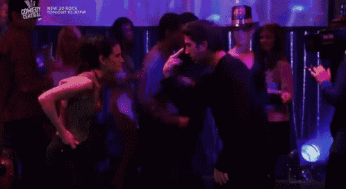 a man and a woman are dancing in a club with a sign that says new 20 rock