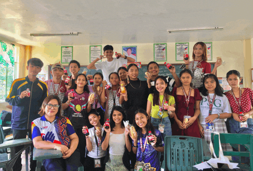 a group of people posing for a picture with one girl wearing a shirt that says p.d.r.
